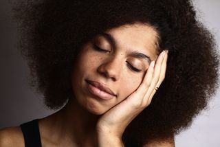 A woman with an afro sleeps.