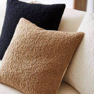 Two West Elm Cozy Boucle Pillow Covers in camel and black