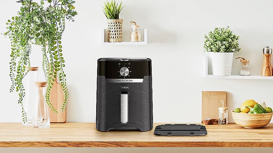A Tefal Easy Fry &amp;amp; Grill Classic Air Fryer EY5018 on a wooden counter