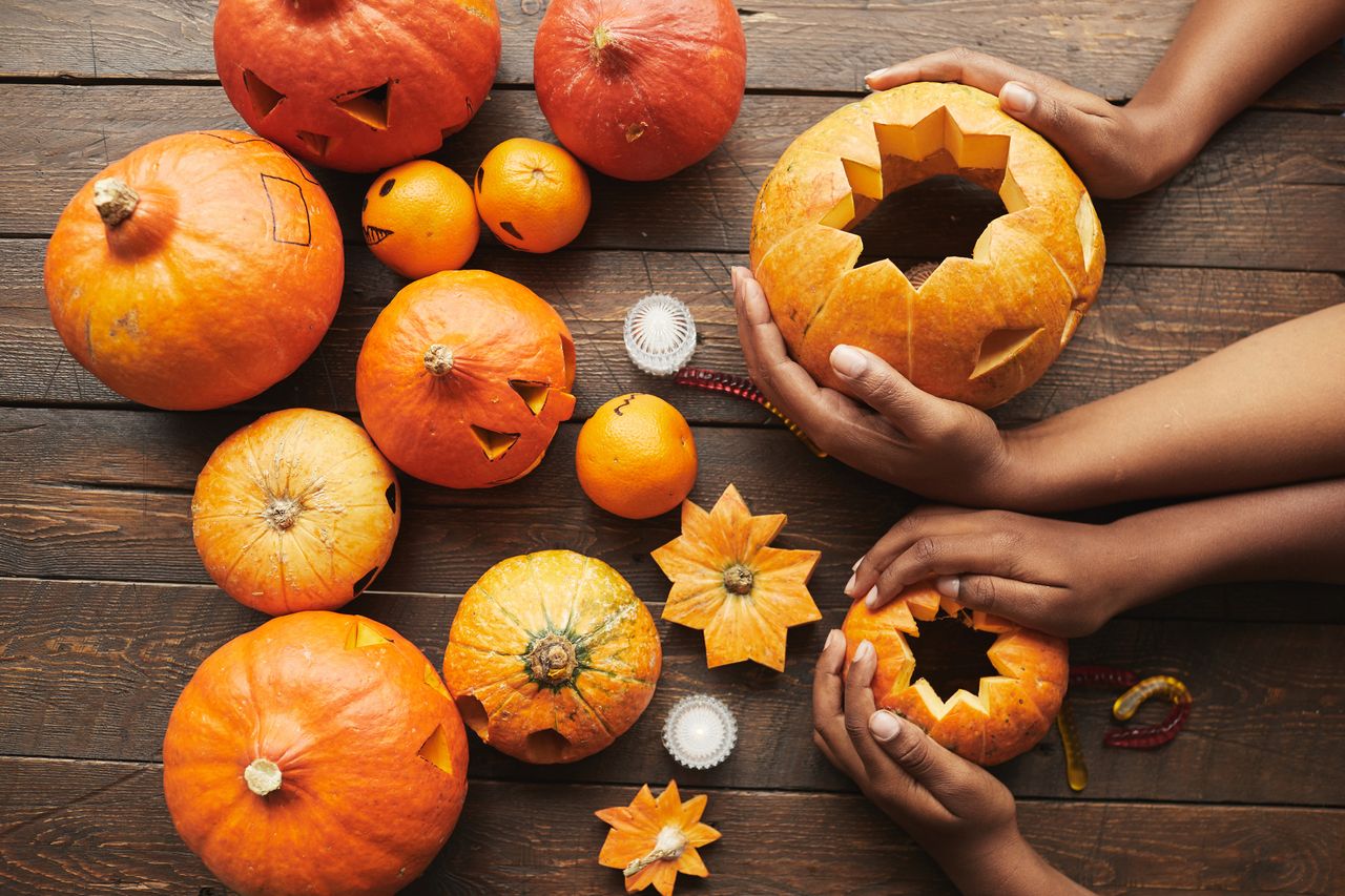 A selection of carved Halloween pumpkins on a wooden table