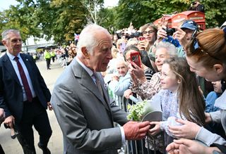 King Charles visits Southport and is given flowers by a stranger in the crowd