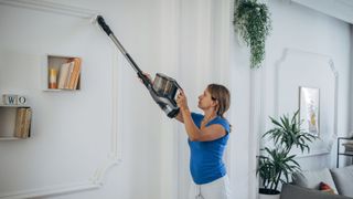 A woman using a cordless vacuum