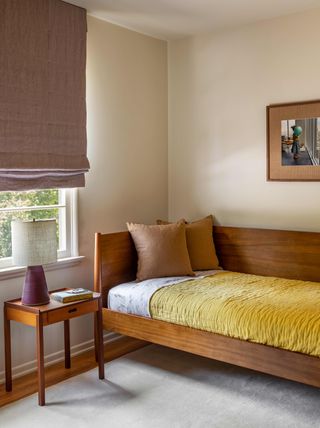 Guest room with wooden bed with yellow bedding