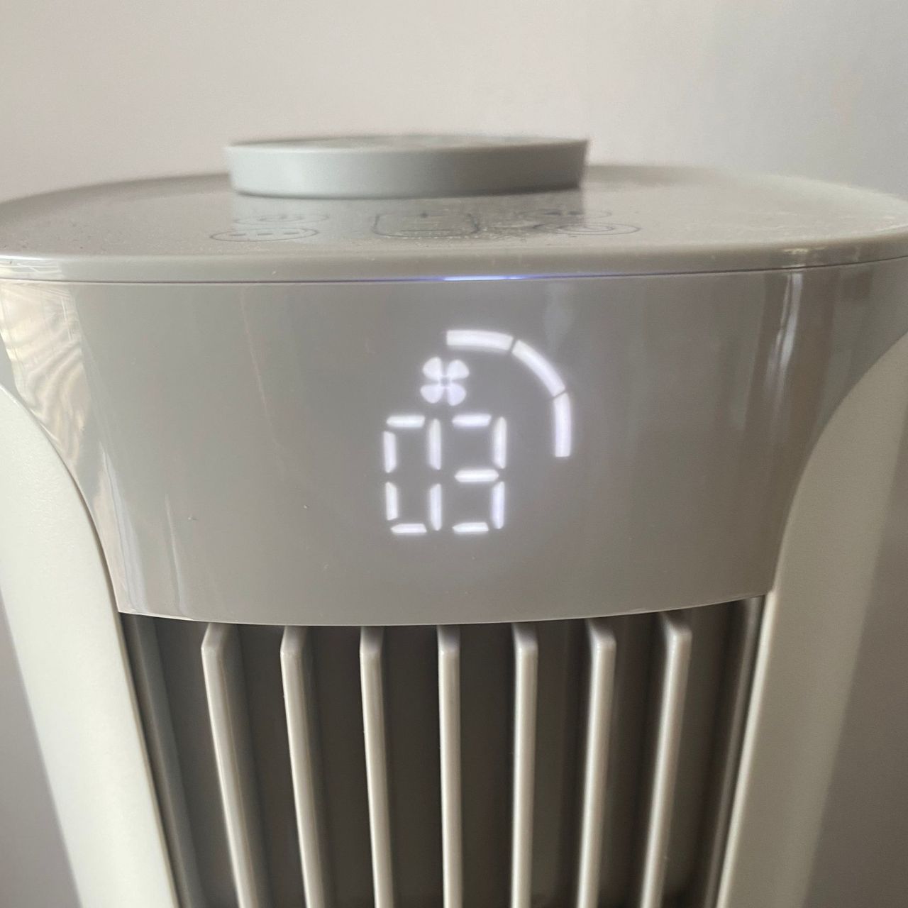 Close up of the Meaco Sefte Tower Fan display, showing wind speed, with the magnetic remote control secured on top
