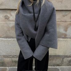@signeemilieolesen outfit closeup in grey jacket with scarf detail and black tassel beaded necklace