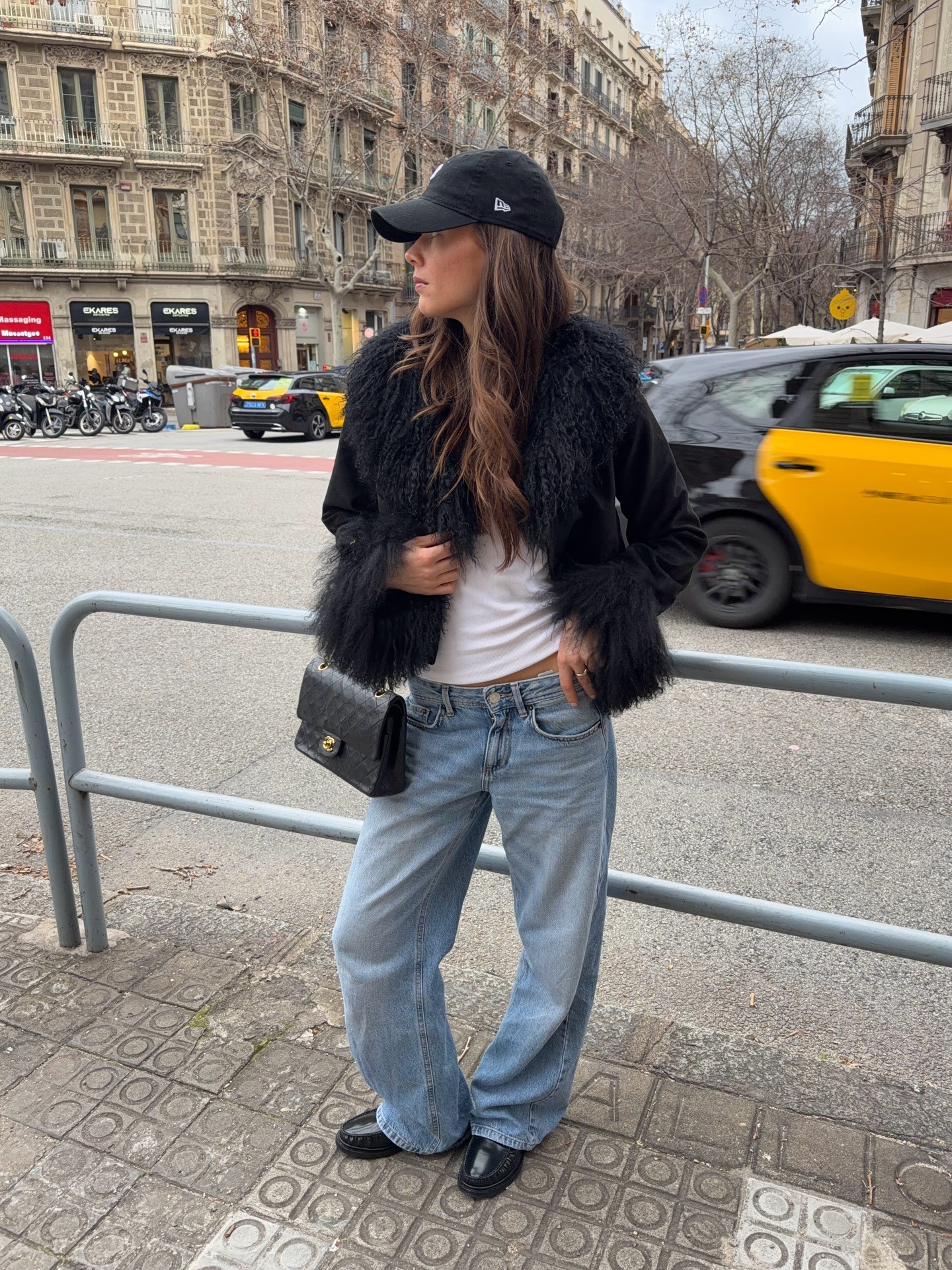 Woman in black faux-fur coat and jeans