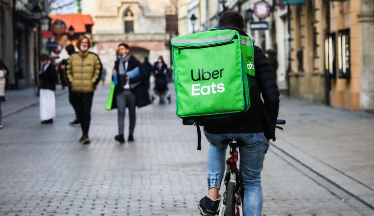 Uber Eats delivery courier is seen riding a bicycle in the center of the city during coronavirus pandemic in Krakow, Poland on March 25, 2021. 
