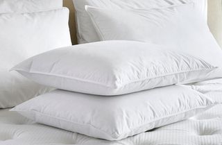 What mattresses do hotels use: Image shows Marriott Hotel pillows stacked on a white Marriott Hotel mattress