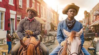 Skuespillerne Idris Elba og Caleb McLaughlin ridder på heste gennem gaderne i en scene fra filmen Concrete Cowboy