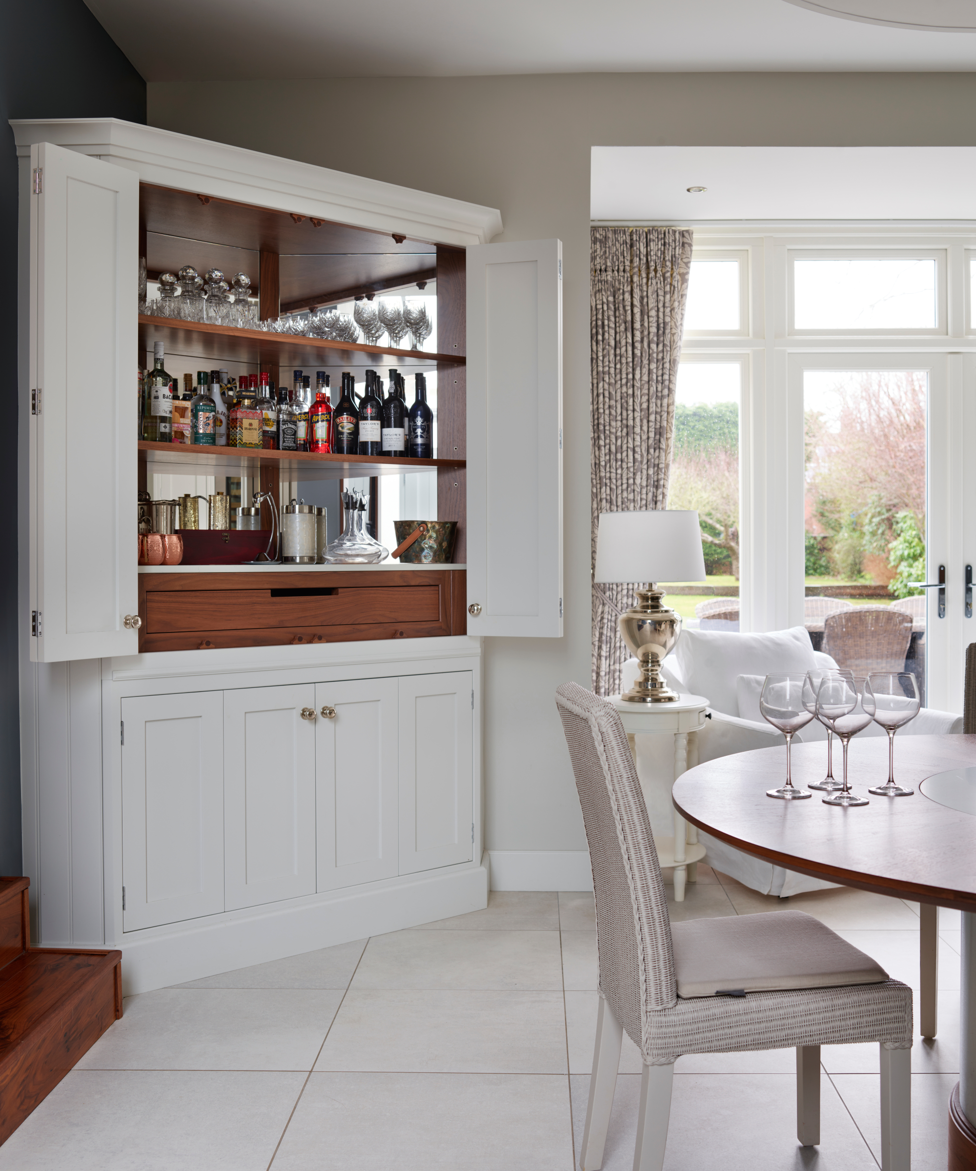 white full-height corner kitchen cabinet with doors open showing bar set-up in side
