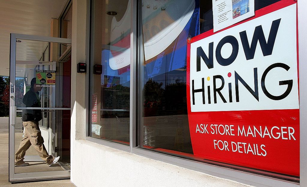 A store window with a help wanted sign.