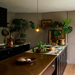 deVOL kitchen with bronze kitchen island and frilly pendant light.