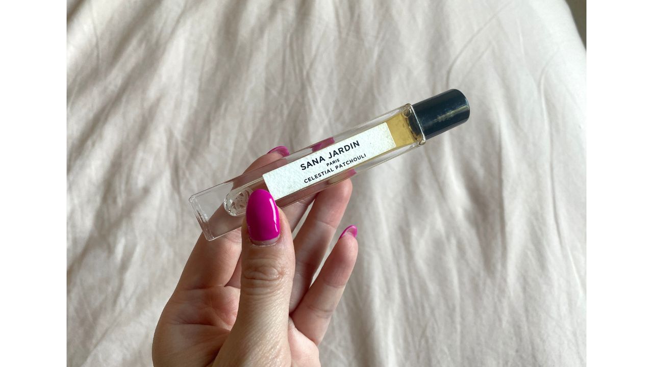 Close up of hand holding a small bottle of Sana Jardin Celestial Patchouli