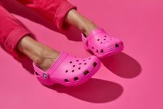 A woman in pink Crocs and pink joggers