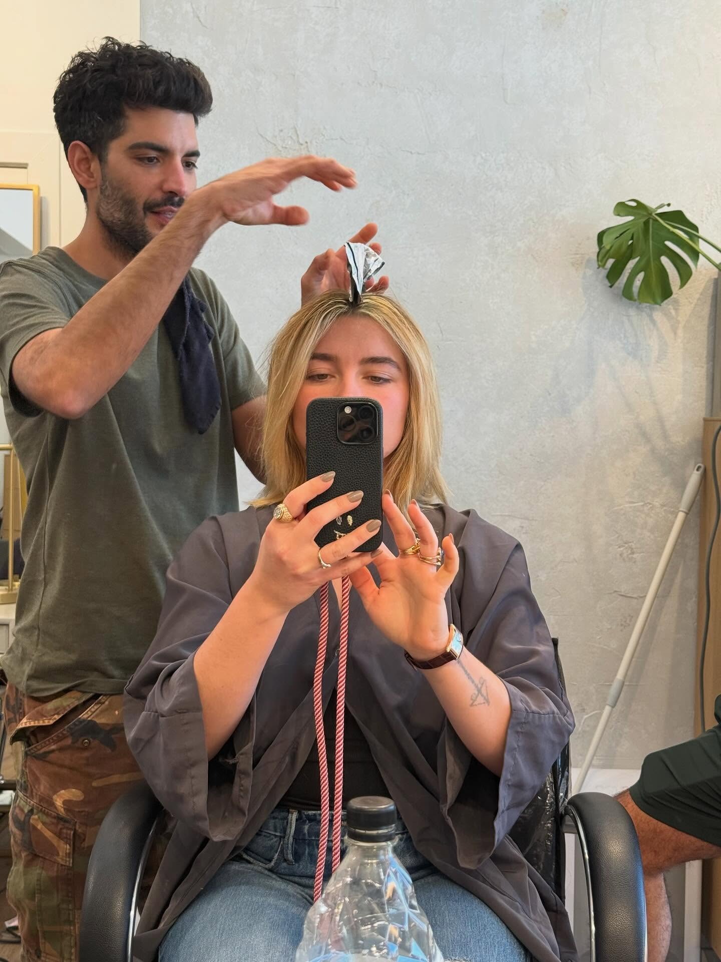 Florence Pugh taking a selfie of having her hair done, with a bob hairstyle and a golden blonde hair colour