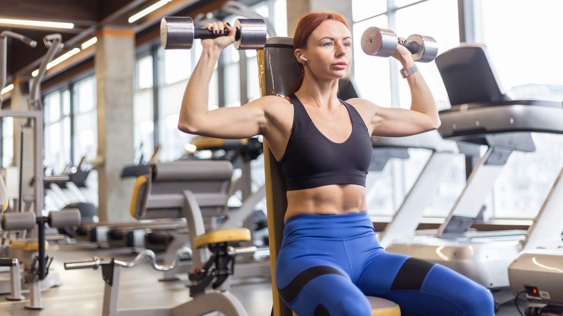 Woman doing a seated Arnold press