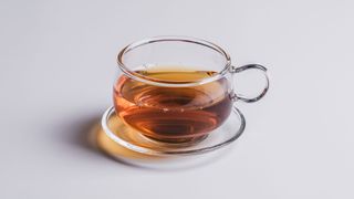 Black tea in glass cup and saucer