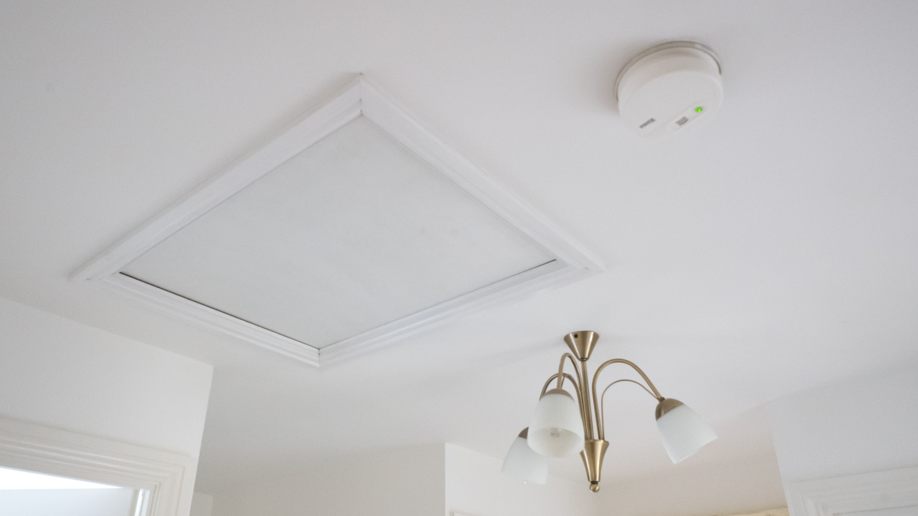 Loft hatch on white painted ceiling.