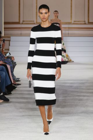 Woman in black and white striped dress and shows on Carolina Herrera runway