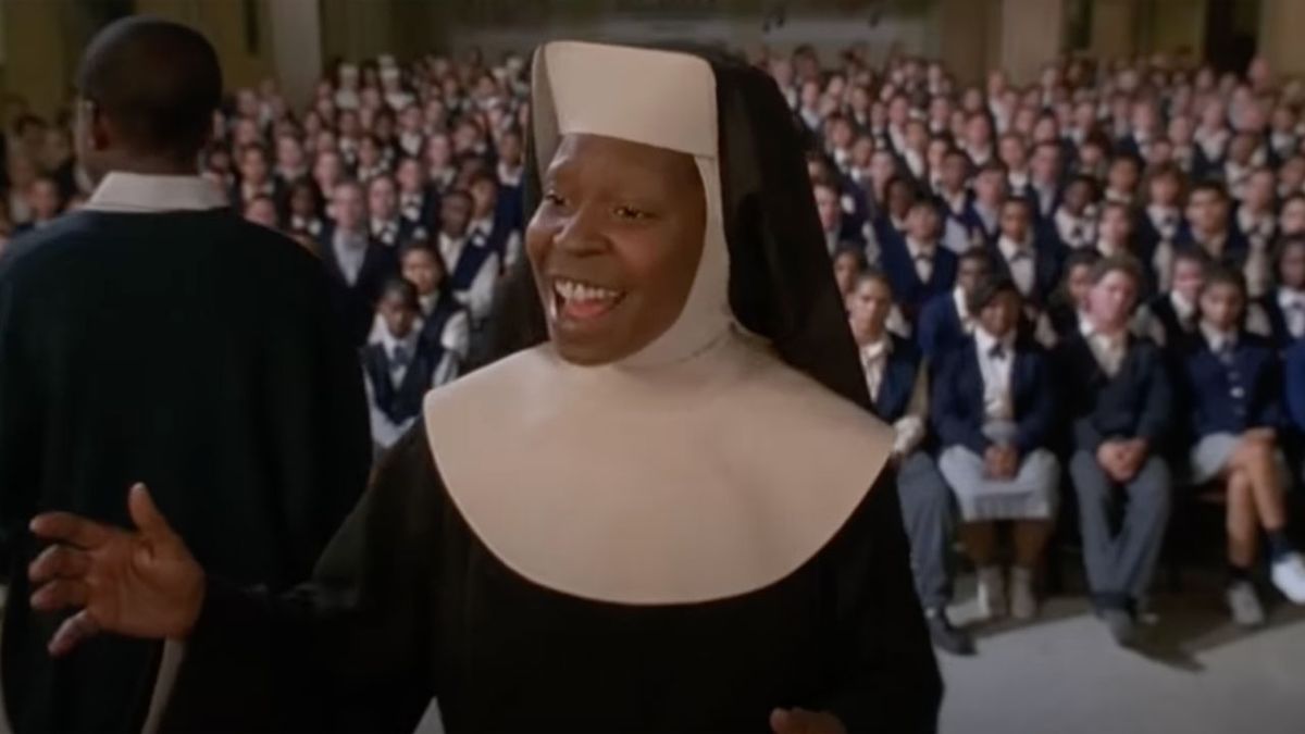 Sister Mary Clarence conducting the choir with an audience in the background.