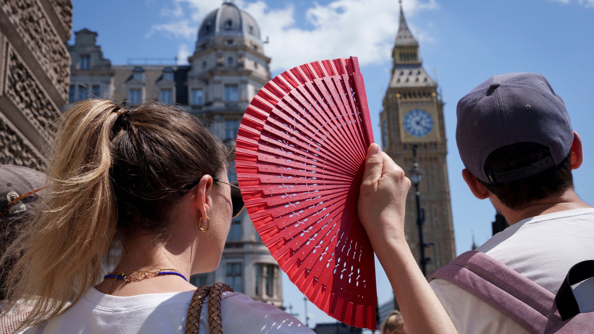  a visitor to the capital fans herself in front of Parliament during the latest heatwave, on 19th June 2026, in London with another Amber Warning for hot weather for the capital
