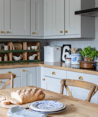 light blue kitchen units with rustic wooden table and vintage accesories