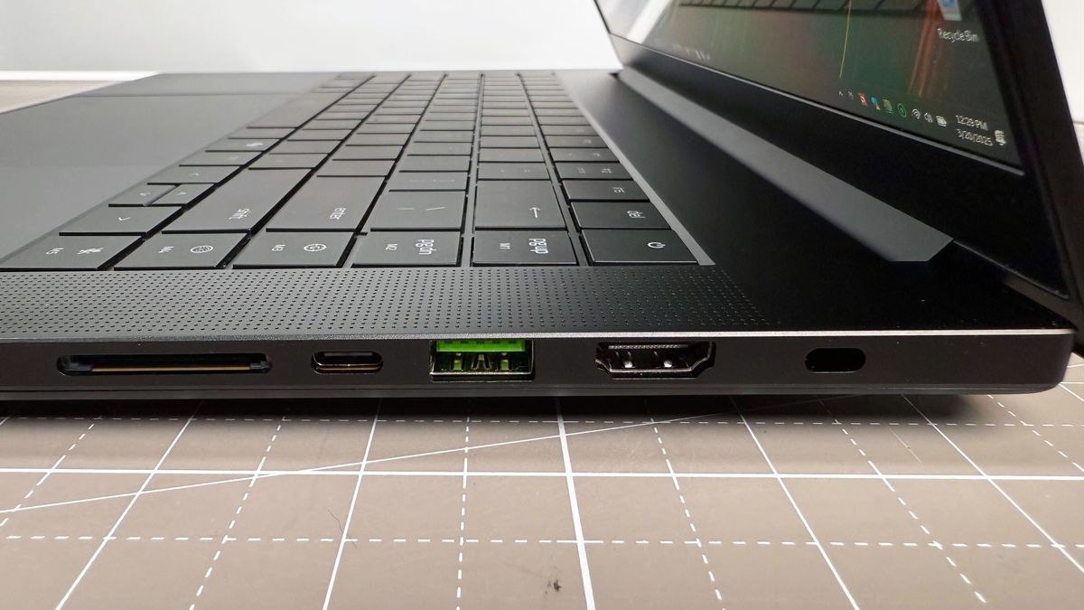 Close up of the right-side port array on the Razer Blade 16 (2025) gaming laptop, on a white and beige desk against a gray backdrop.