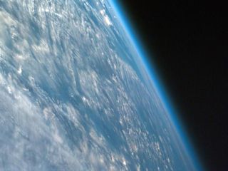 Earth is surrounded by a thin layer of atmosphere.