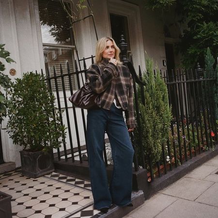 Influencer @lucywilliams02 wears dark wash jeans with a checked jacket.
