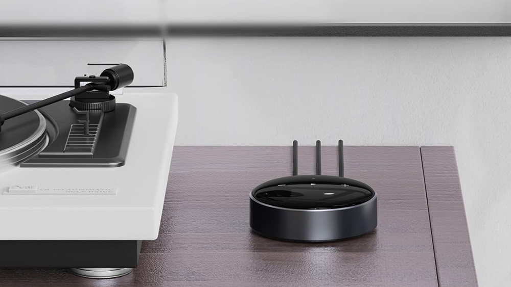 WiiM Mini on a desktop next to a turntable