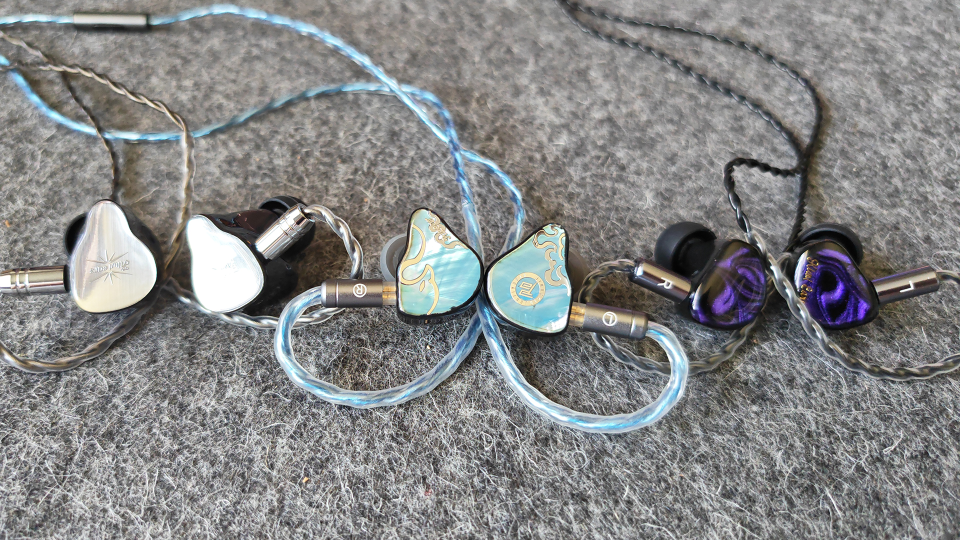 Three IEMs on a felt mat.