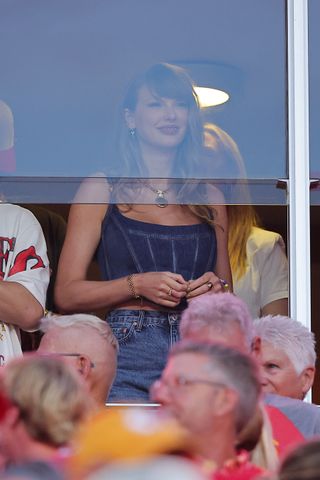 Taylor Swift attends the Chiefs Ravens game wearing a denim versace corset and jean shorts