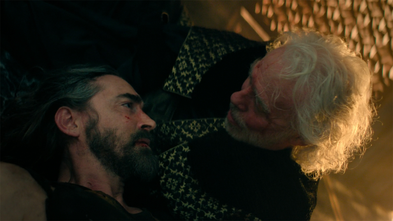 Brother Darkness lying down next to a dying Brother Day in Foundation season 3 episode 10