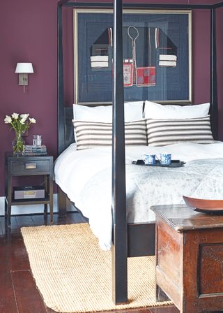 Bedroom image with purple walls and black four poster bed