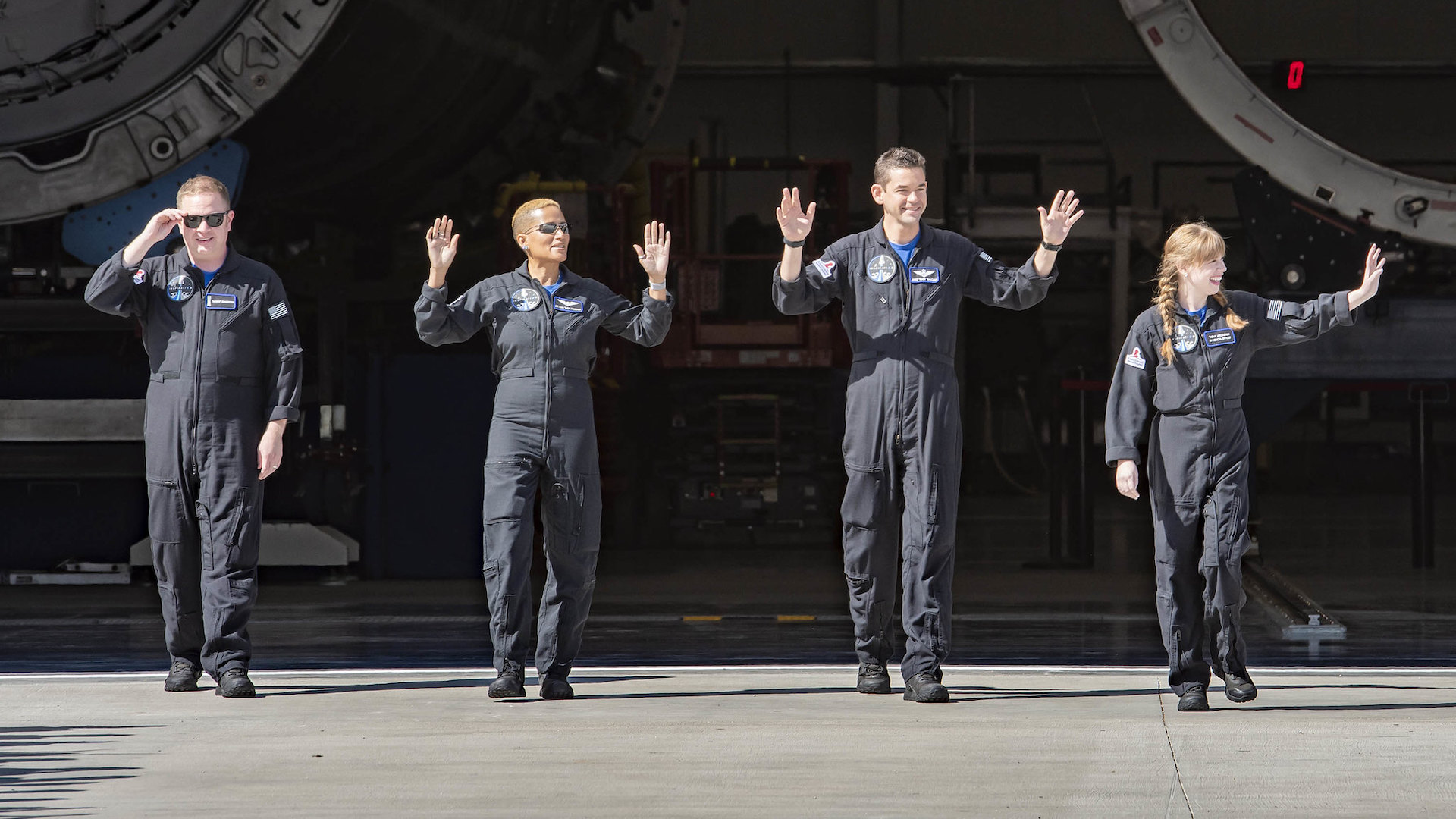 Four crew members of the Inspiration 4 mission wave to the cameras.