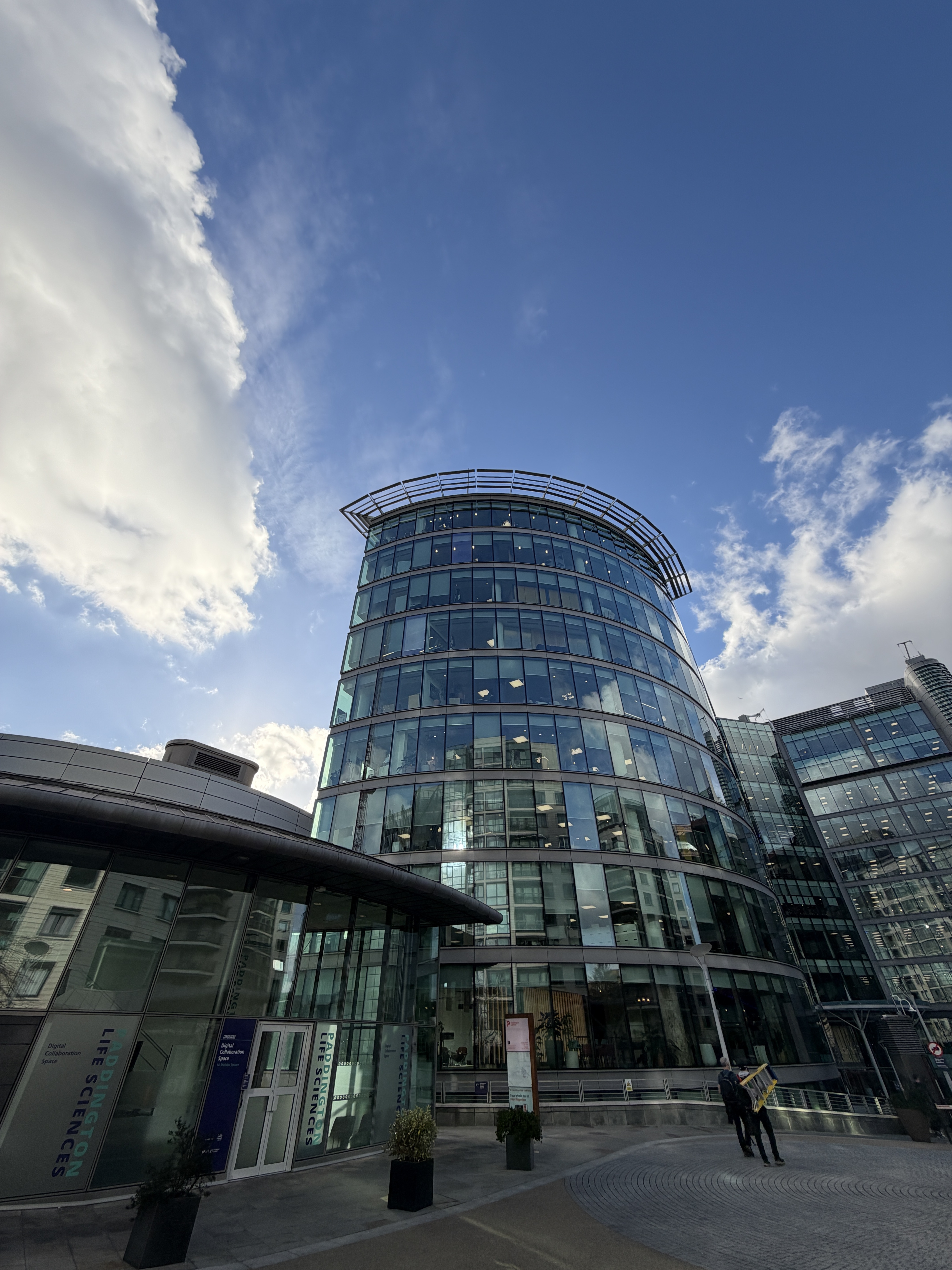 A picture of a glass office building during the day