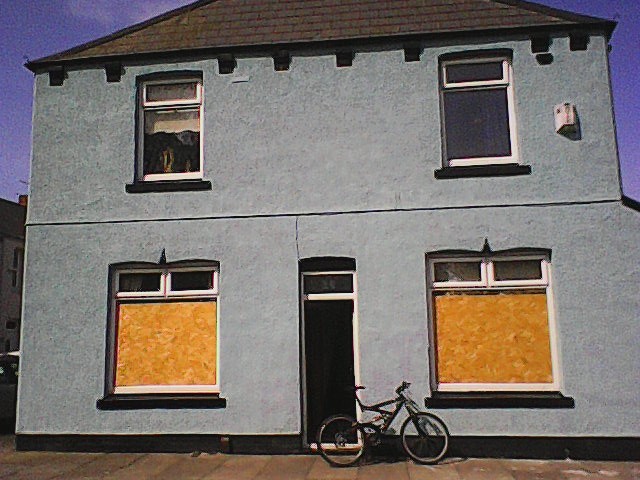 Low res photo taken on dumbphone of bicycle in front of house