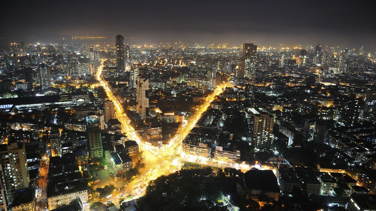 An aerial view of Mumbai at night, lit up by lights