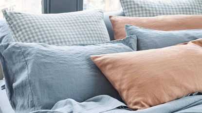 how to choose a pillow: Pillows of different colors layered on a bed
