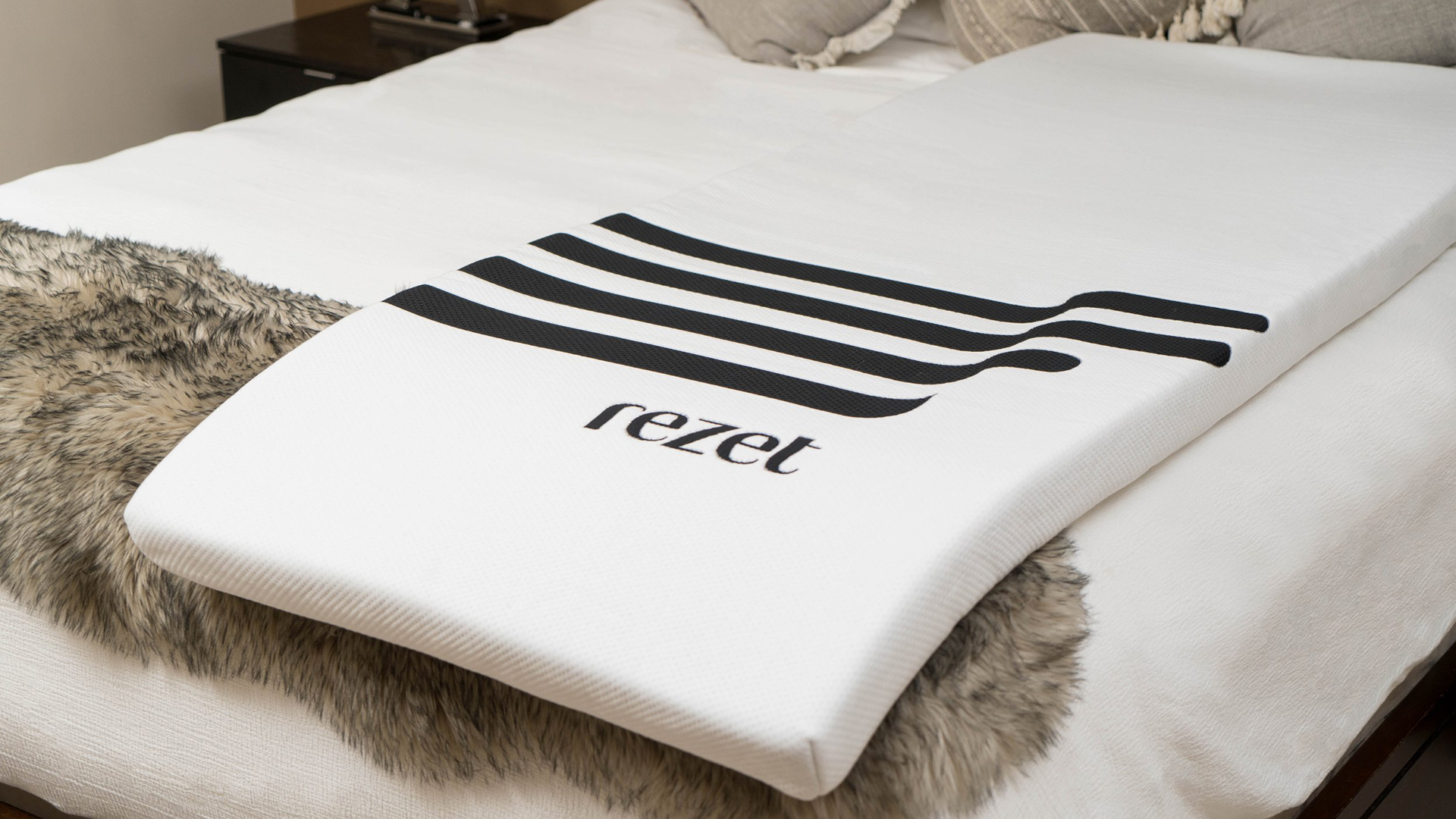 A Rezet mattress topper lying on a bed in a bedroom