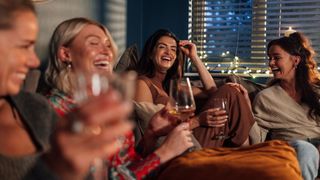 A group of women laughing over wine