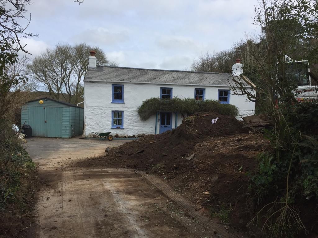 A before picture of a cornish cottage with white cement render