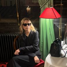 A woman wearing a black coat and sunglasses