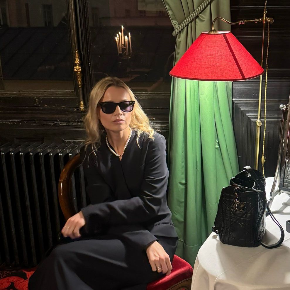 A woman wearing a black coat and sunglasses