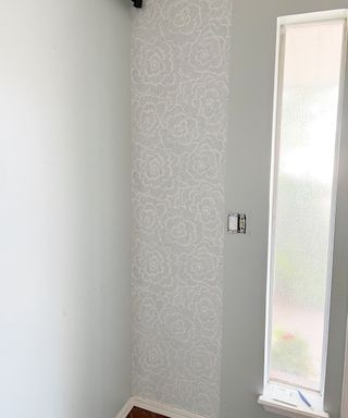 Blue grey peel and stick wallpaper application with exposed outlet