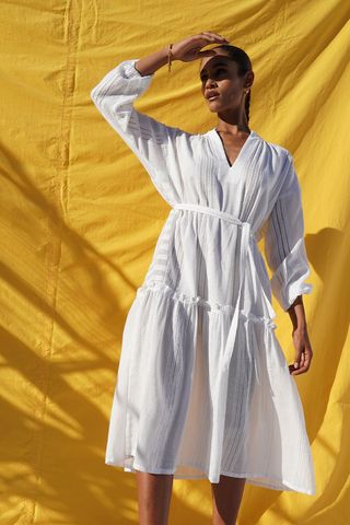 A model wearing a tiered white dress by Lemlem