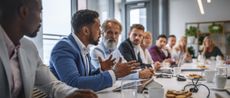 Executive team listening to contrary views from colleague in corporate board room