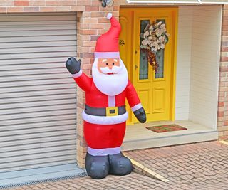 inflatable santa stood outside house