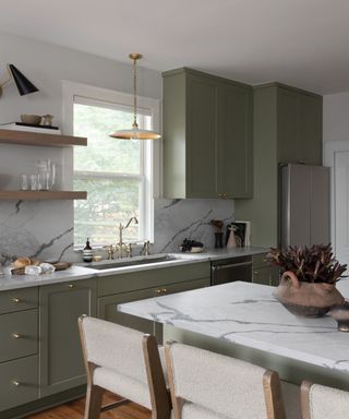 A kitchen with light green cabinets and stainless steel appliances