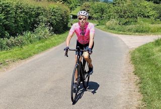 A rider in a pink jersey cycling in the UK